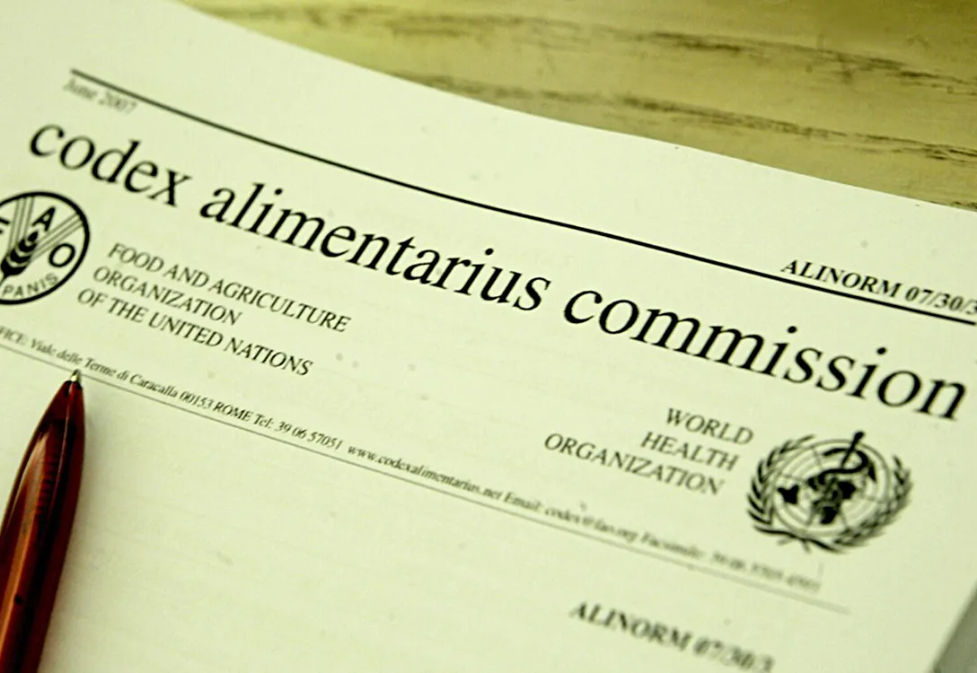 Close-up image of a printed document about Codex Alimentarius on a table.